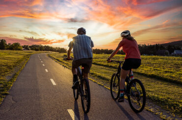Two people riding bikes along a country road