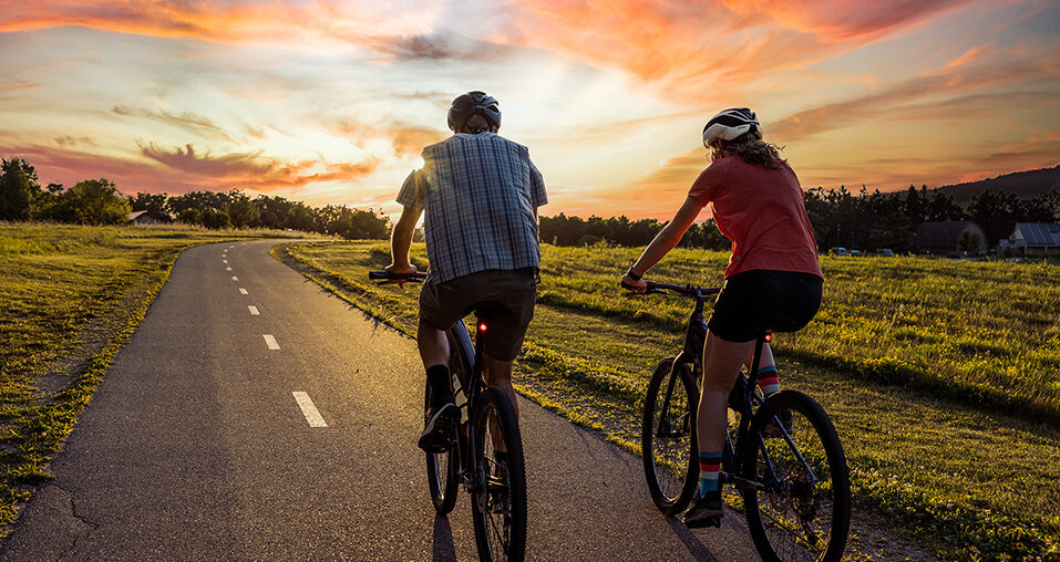 Two people riding bikes along a country road